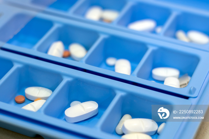 Detail of pill organiser with pills.