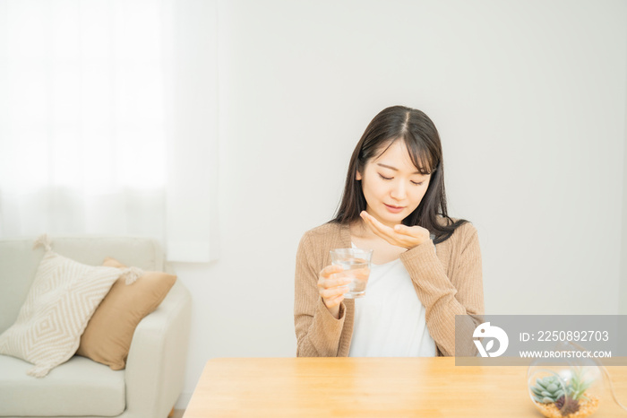 薬を飲む女性