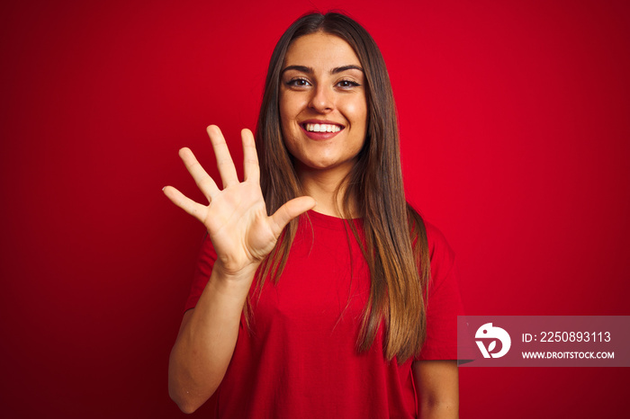 Young beautiful woman wearing t-shirt standing over isolated red background showing and pointing up 