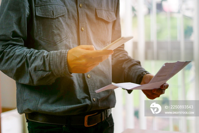 Man checklist using bank of credit card by mobile phone and pay bills in the office