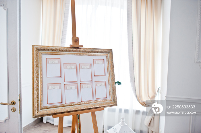 Wedding seating chart on the easel at light restaurant.