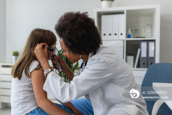 美国非裔女医生，全科医生，检查患病儿童的耳朵。耳朵感染。