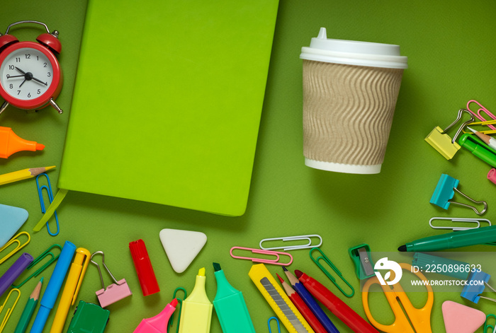 School office supplies on a desk with copy space. Back to school concept. School supplies on green b