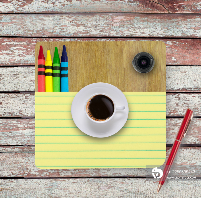 木桌上的笔记本、一杯咖啡、铅笔
