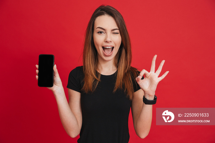 现代高加索女性在为新手机做广告时高兴并展示ok标志，被隔离了