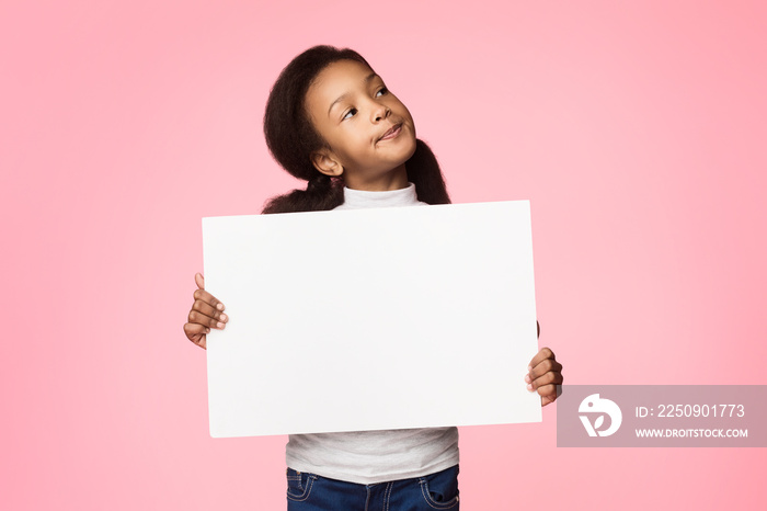 Little thoughtful girl holding blank board over background