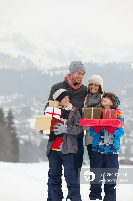 Happy family with Christmas gifts in snowy field