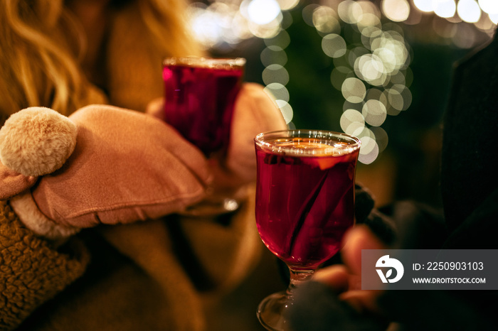 Close-up womans hands in winter mittens with hot cup of hot mulled wine. Holidays, traditions, wint