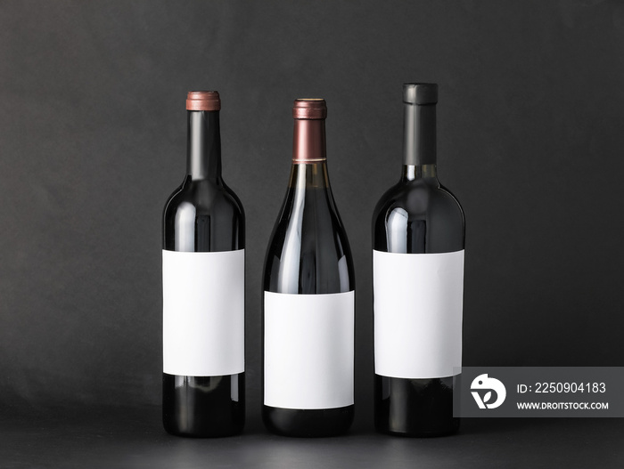 Bottles of wine with blank labels on dark background. Mockup for design