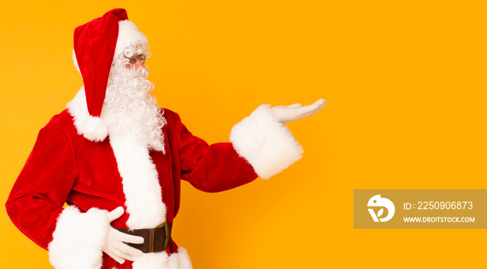 Santa Claus holding copy space on palm over orange