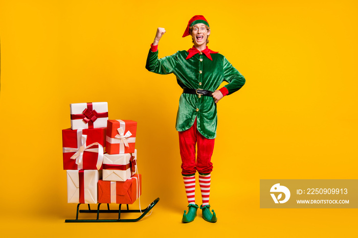 Full length body size view of his he nice attractive cheerful cheery funny guy elf carrying gifts on