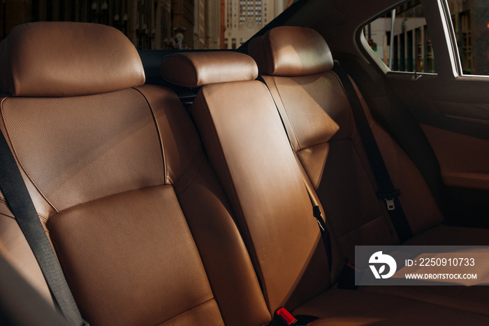 Cozy leather seats at the back row of a modern luxury sedan. Vip transfer car at the city street. Vi