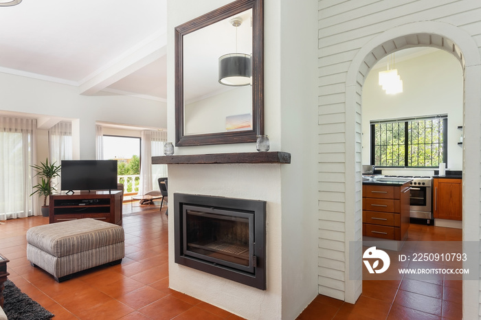 Modern traditional European living room with fireplace and views of the kitchen and outside.