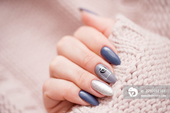 Beautiful female manicure on a soft sweater sweater.