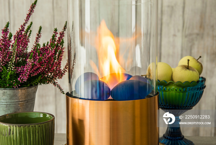 木质桌子上燃烧生物乙醇气体的独立便携式玻璃和铜金属壁炉