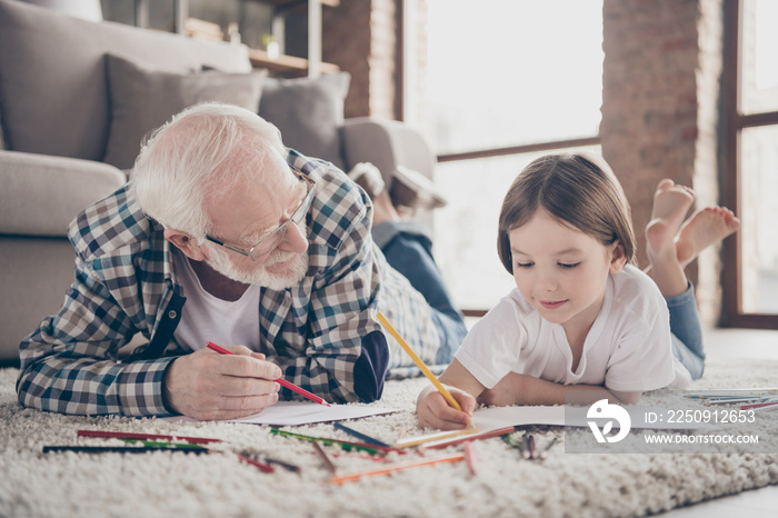 Closeup photo of grandpa spending time little granddaughter lying comfy fluffy floor carpet painting