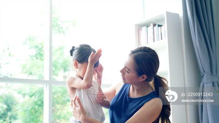 Asian Mother comforting her daughter from a minor injury during the morning yoga practicing session