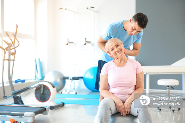 Physiotherapist working with mature patient in rehabilitation center