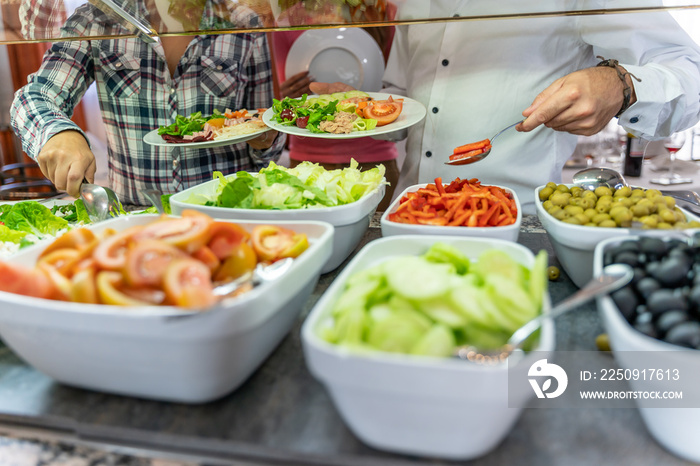 人们从一家充满健康食品的自助餐厅拿食物的细节