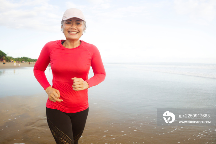 fit and attractive mature woman with grey hair doing beach workout on her 50s running on the beach h