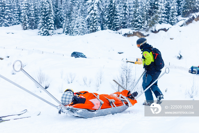 Ski rescue team with slide stretcher, brings help to ski during bad weather conditions.