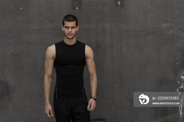 Sport model man posing gray wall background