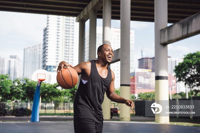 Men on basketball court holding basketball looking away smiling