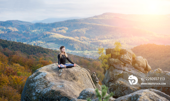 运动型年轻女性正在山顶练习瑜伽和体式Siddhasana