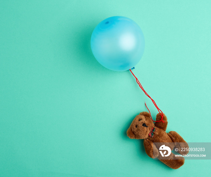 little brown teddy bear holding a pink inflated balloon