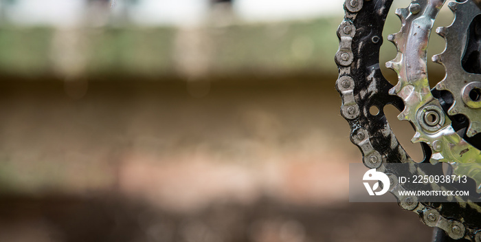 Close-up of gears and a chain to drive a bicycle. The chain is dirty and greasy. Copy space