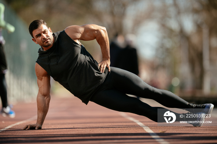 Athlete warming up. Man doing plank. Guy warming up before a workout.