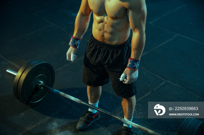 Caucasian man practicing in weightlifting in gym. Caucasian male sportive model preparing for traini