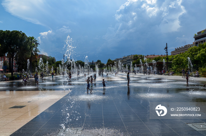 Water games on Promenade du Paillon in Nice. Water reflecting fountain surrounded by beautiful histo