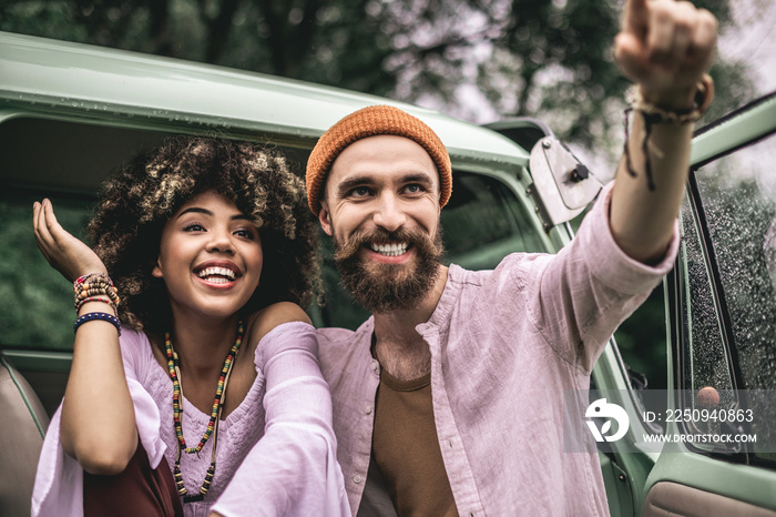 Happy hipster man and woman near retro van