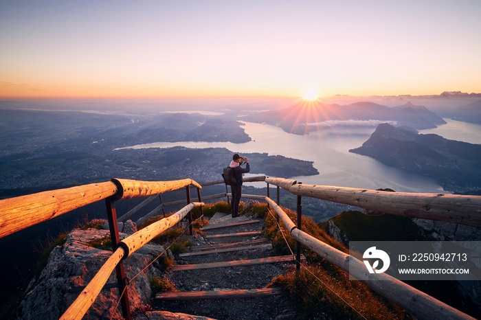 Man photographing landscape at beautiful sunrise