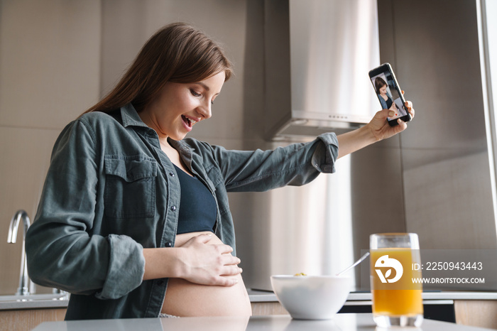 孕妇吃早餐时用手机自拍的照片