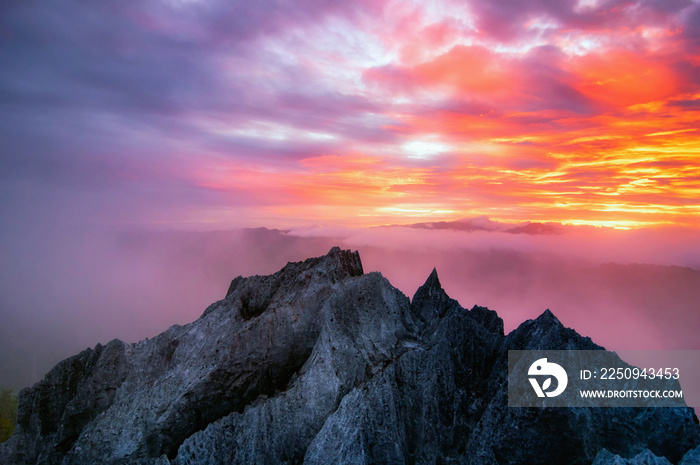 鸟瞰美丽的岩石晨曦金色的日出和薄雾在高牟上流动