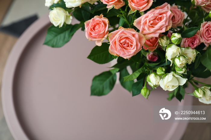 Bouquet of beautiful fresh roses on table in room, closeup