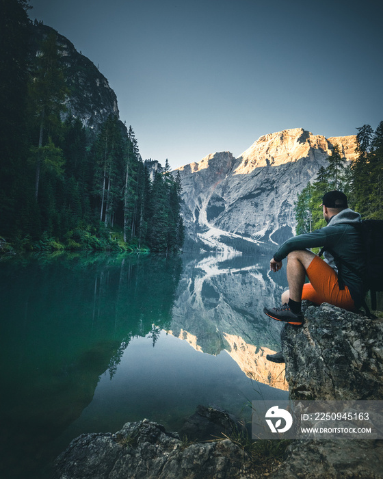 Man at Lago di Braies Lake in Italy with a perfect Reflection of the Mountain