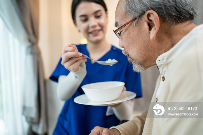 亚洲美女治疗师医生为家里的老年患者提供食物。