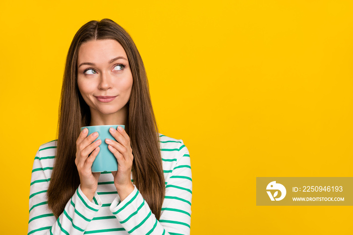 Photo of dreamy cute young woman wear striped shirt drinking looking empty space isolated yellow col