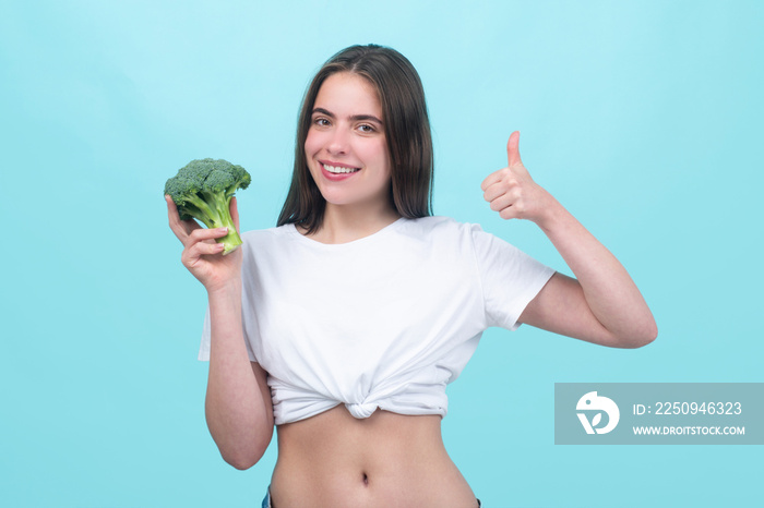 Healthy food, health lifestyle, diet. Beautiful woman eating fresh vegetable green broccoli, shows t