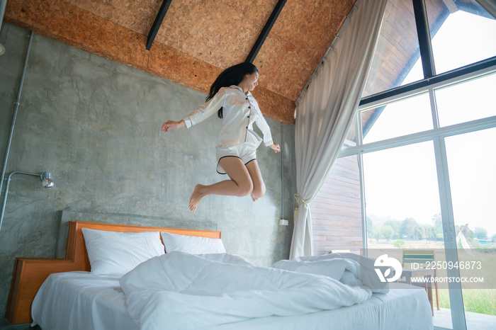 attractive asian woman jumping on bed in the morning, in the morning, She felt very refreshed, natur