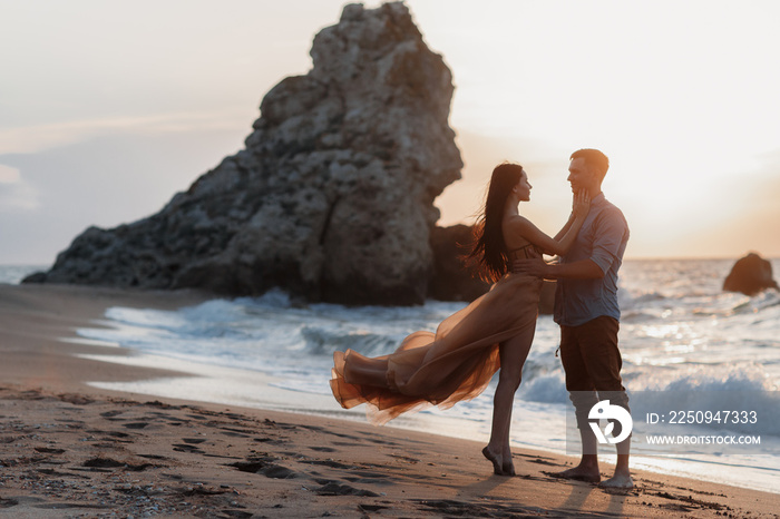 Couple in love at dawn by the sea. Honeymoon trip. Man and woman traveling. Happy couple by the sea 