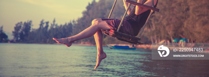 slender female legs close up, woman swinging on a swing on the beach during sunset, rest, travel, li