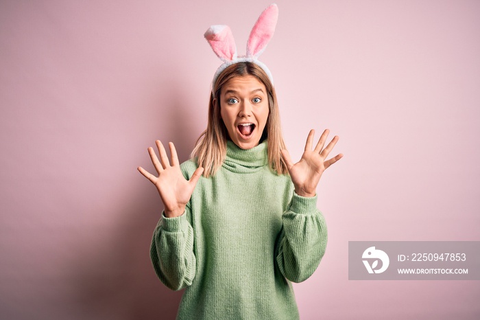 Young beautiful woman wearing easter rabbit ears standing over isolated pink background celebrating 