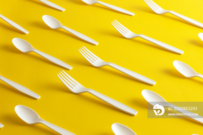 Disposable plastic cutlery forks and spoons forbidden with yellow background