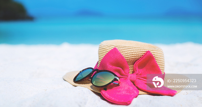 Straw hat and sun glasses on beach