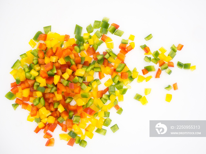 Red, green and yellow sweet bell peppers chopped on white background