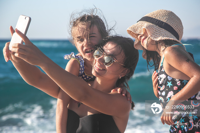 A mom with a child taking a selfie on the background of the sea